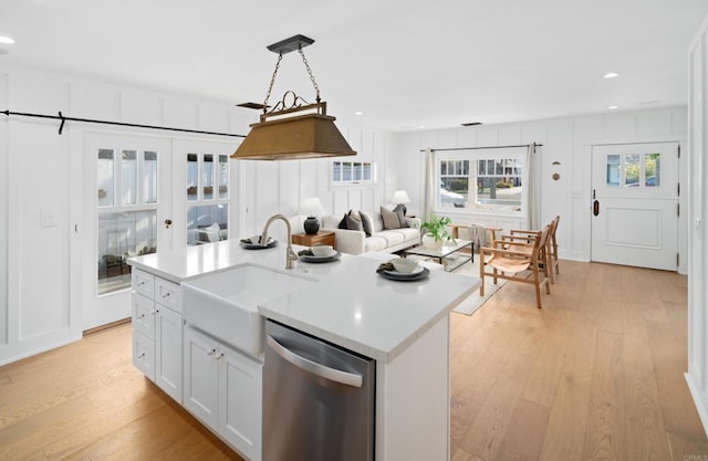 kitchen with sink, white cabinets, an island with sink, and dishwasher