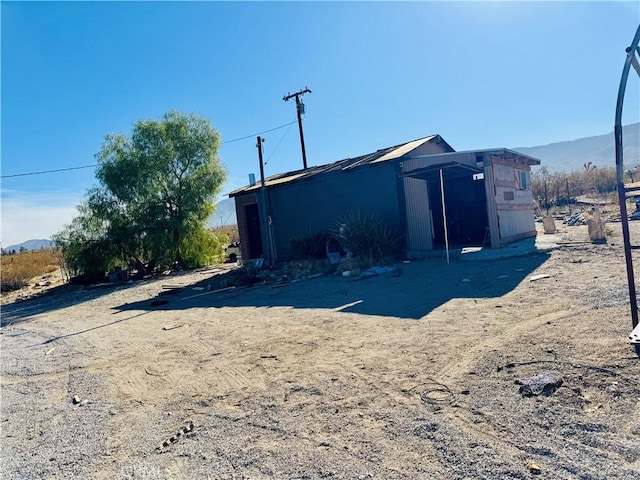 back of house featuring an outbuilding and a mountain view