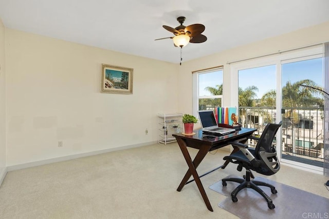 home office with carpet flooring, a ceiling fan, and baseboards