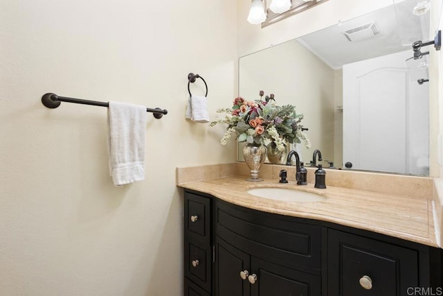 bathroom with visible vents, crown molding, and vanity