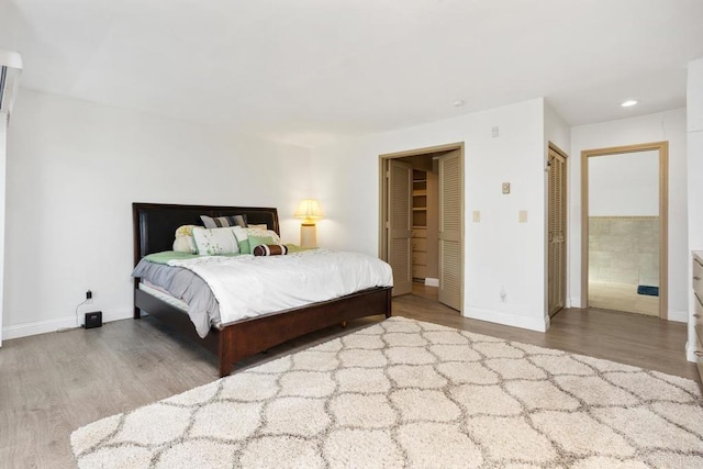 bedroom with recessed lighting, wood finished floors, and baseboards