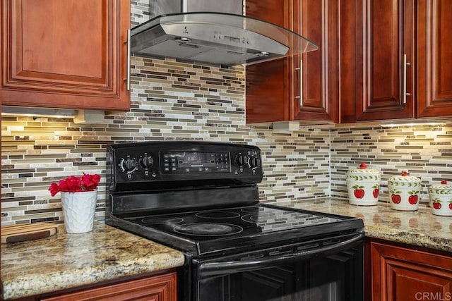 kitchen featuring tasteful backsplash, electric range, wall chimney range hood, dark brown cabinets, and light stone countertops