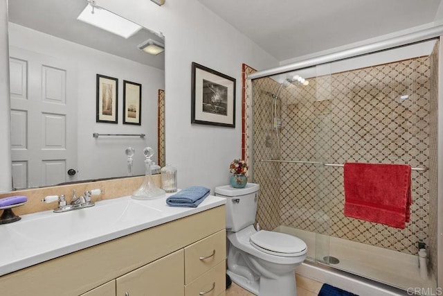 bathroom with a shower stall, toilet, and vanity