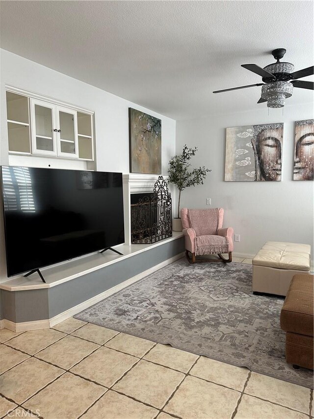 unfurnished living room with ceiling fan, tile patterned flooring, and a textured ceiling