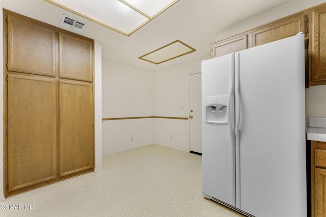 kitchen featuring white refrigerator with ice dispenser