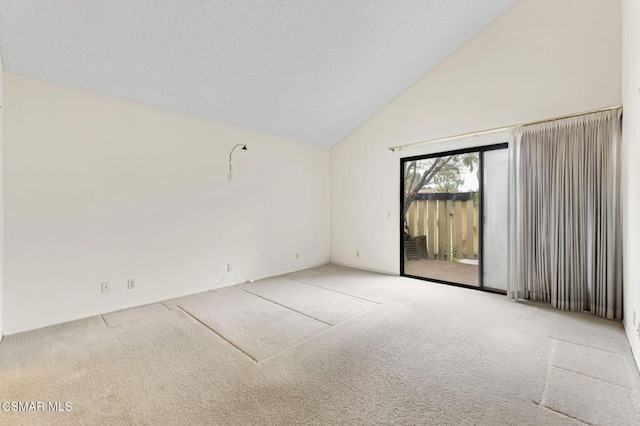 carpeted spare room featuring high vaulted ceiling and a textured ceiling