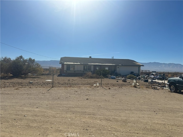 rear view of property with a mountain view and a garage