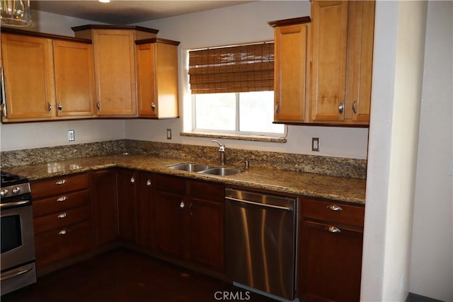 kitchen with sink, stainless steel appliances, and dark stone counters