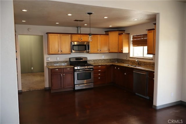 kitchen featuring pendant lighting, sink, stainless steel appliances, and dark stone countertops