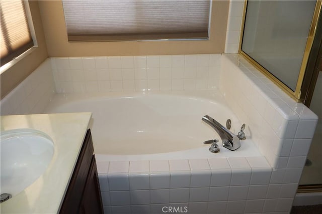 bathroom with vanity and tiled bath