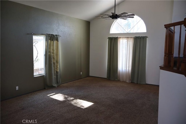 empty room with ceiling fan, high vaulted ceiling, and dark carpet