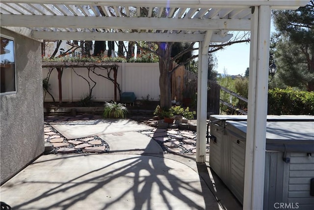 view of patio with a hot tub and a pergola