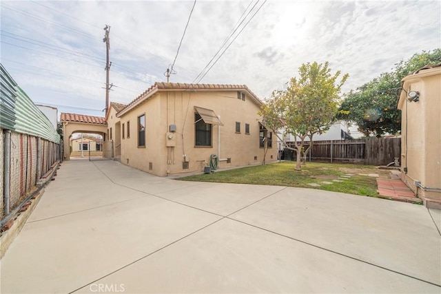 back of property with a yard and a patio area