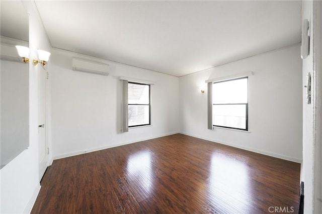 unfurnished room featuring a chandelier, a healthy amount of sunlight, dark wood-type flooring, and a wall unit AC