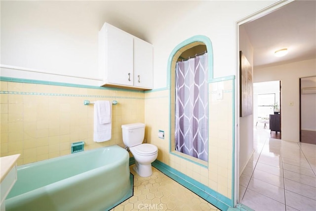 bathroom featuring tile walls, tile patterned floors, toilet, and separate shower and tub