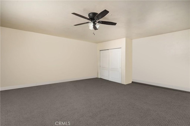 interior space with dark carpet, a closet, and ceiling fan