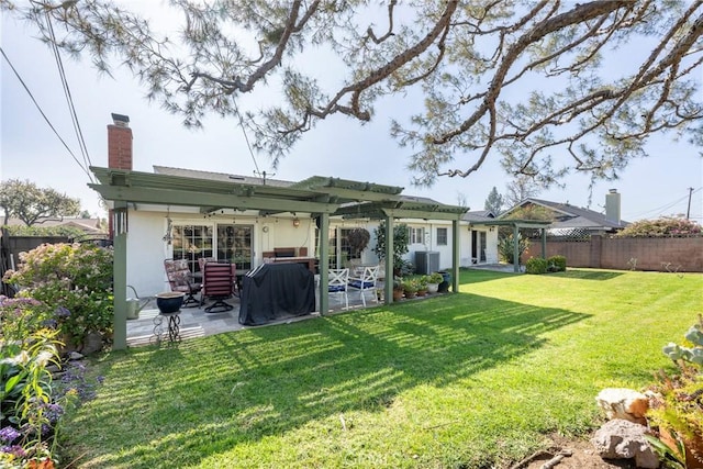 rear view of house with a lawn, central AC unit, and a patio area