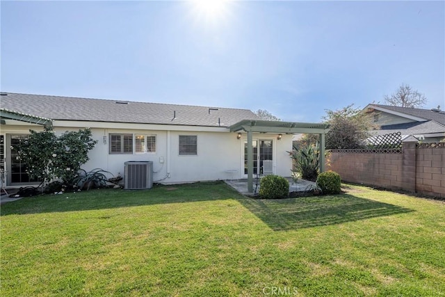 back of property featuring central AC unit and a lawn