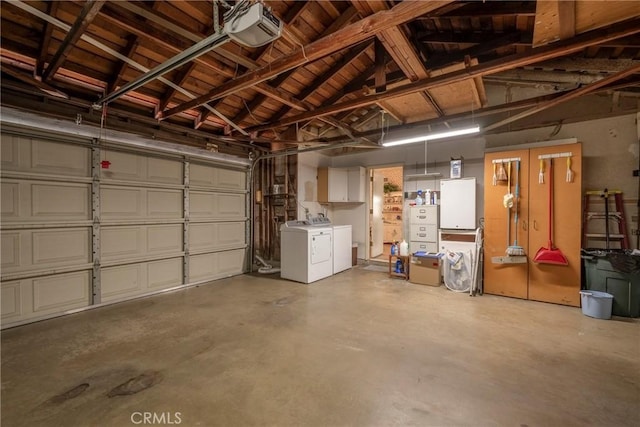 garage with a garage door opener and washer and dryer