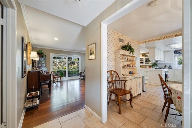 interior space with white cabinetry, ornamental molding, and a wealth of natural light