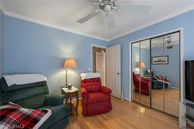 living area with ornamental molding, ceiling fan, and light hardwood / wood-style flooring