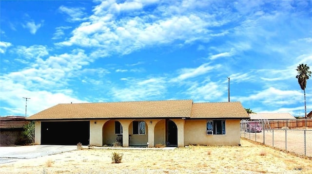 single story home featuring a garage, fence, and stucco siding