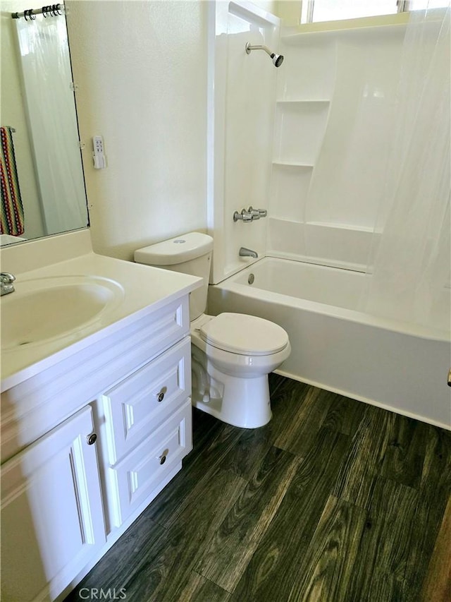 bathroom with vanity,  shower combination, wood finished floors, and toilet