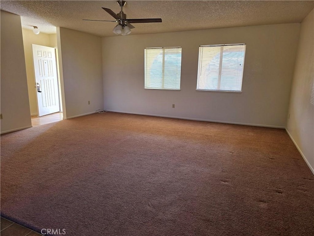 carpeted empty room featuring a ceiling fan, a textured ceiling, and baseboards