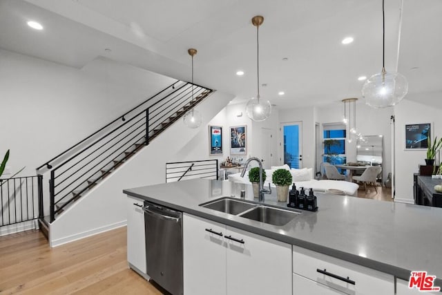 kitchen with sink, hanging light fixtures, dishwasher, light hardwood / wood-style floors, and white cabinets