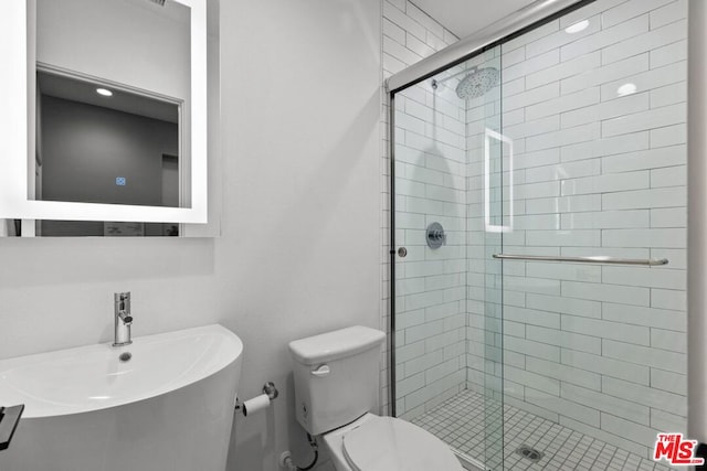 bathroom featuring walk in shower, toilet, and sink