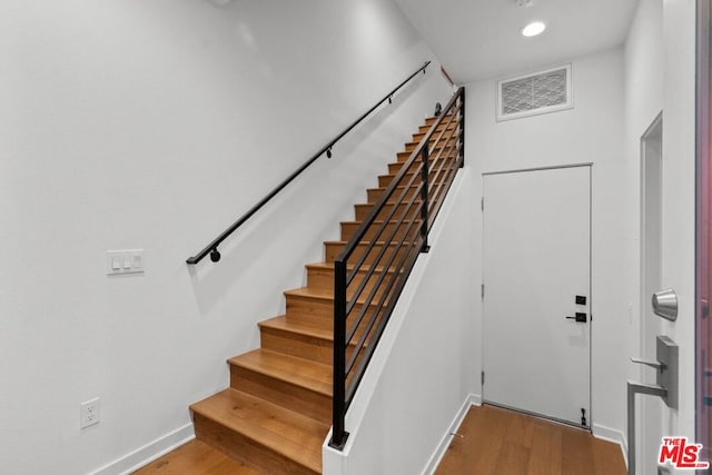 staircase with hardwood / wood-style flooring