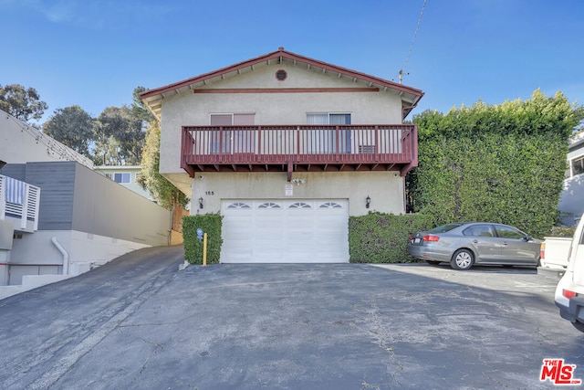 view of front of house featuring a balcony and a garage