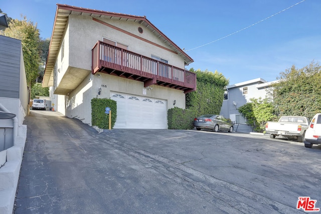 view of front of home with a garage and a balcony