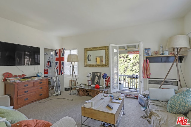 living room with light colored carpet and an AC wall unit