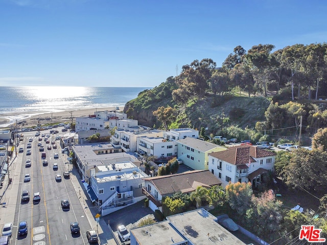 birds eye view of property with a water view and a beach view