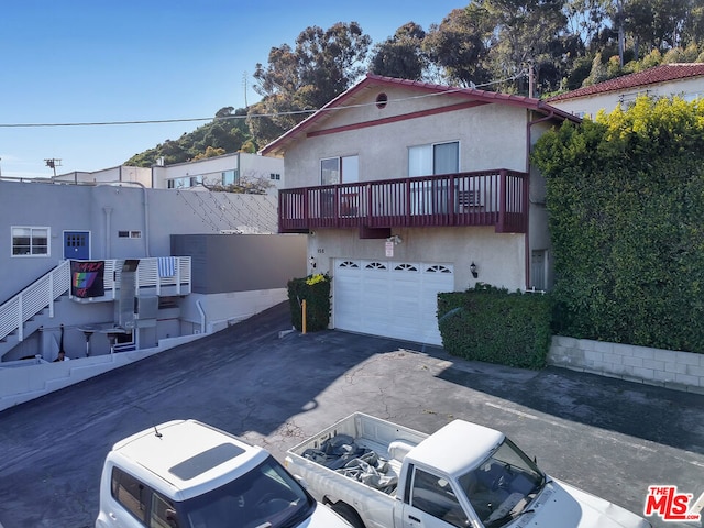 view of front of house featuring a garage and a balcony