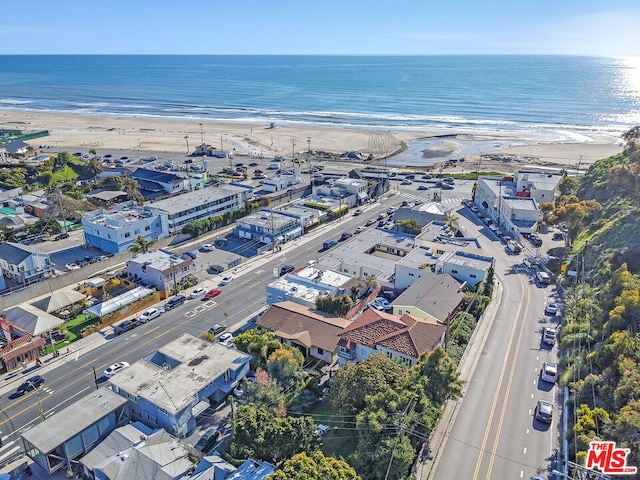 birds eye view of property with a water view and a beach view