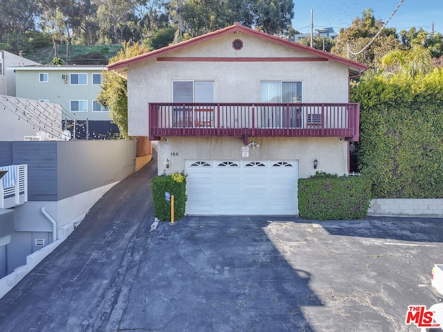 view of front of home featuring a garage and a balcony