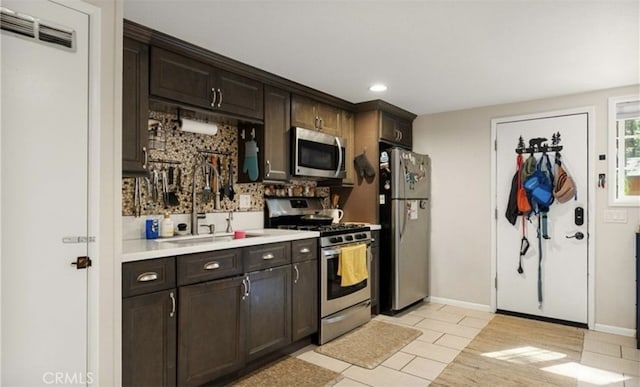 kitchen featuring appliances with stainless steel finishes, dark brown cabinets, and sink