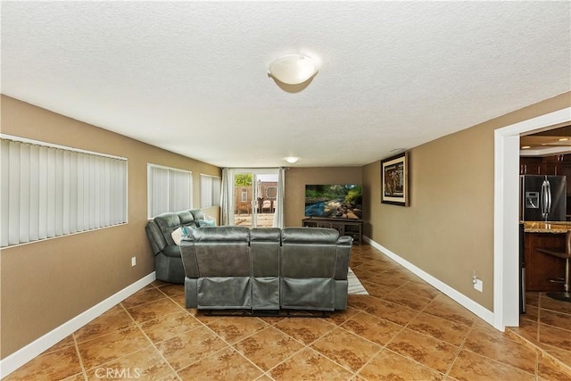 tiled living room featuring a textured ceiling