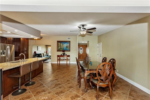 tiled dining space featuring sink and ceiling fan