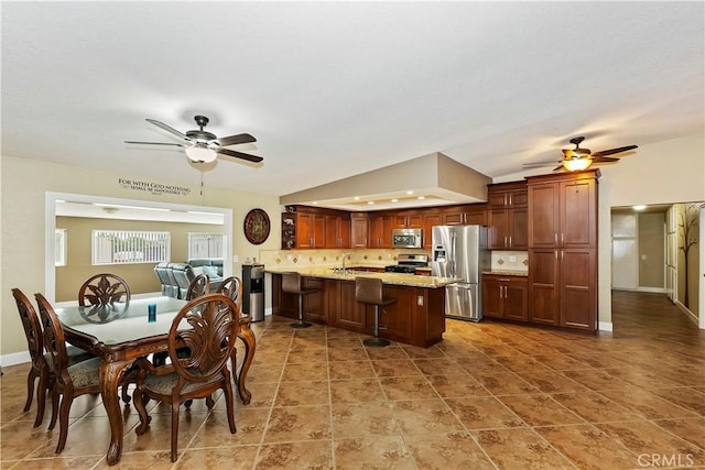 dining space featuring ceiling fan, sink, tile patterned flooring, and vaulted ceiling