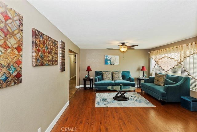 living room with dark wood-type flooring and ceiling fan