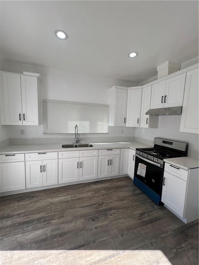 kitchen with stainless steel range with gas cooktop, sink, white cabinets, and dark hardwood / wood-style floors