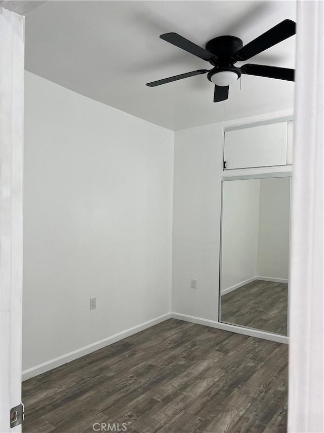 unfurnished bedroom featuring ceiling fan, dark hardwood / wood-style floors, and a closet