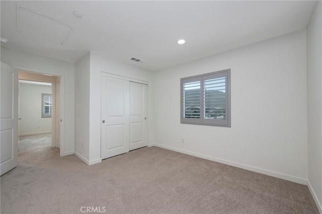 unfurnished bedroom with light carpet and a closet