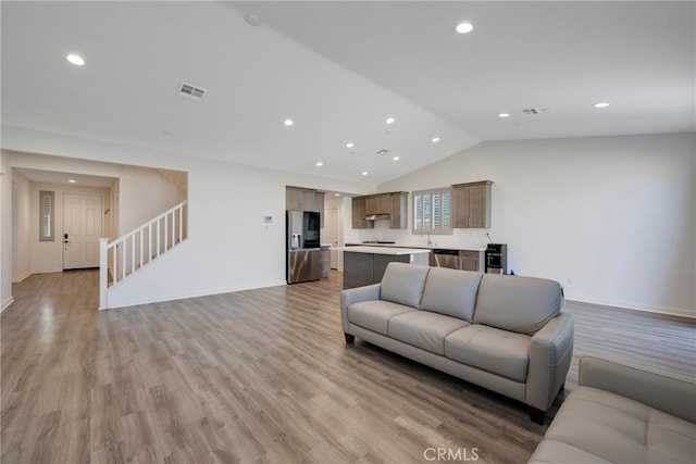 living room with lofted ceiling and light wood-type flooring