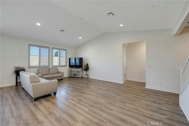 living room with vaulted ceiling and light hardwood / wood-style floors