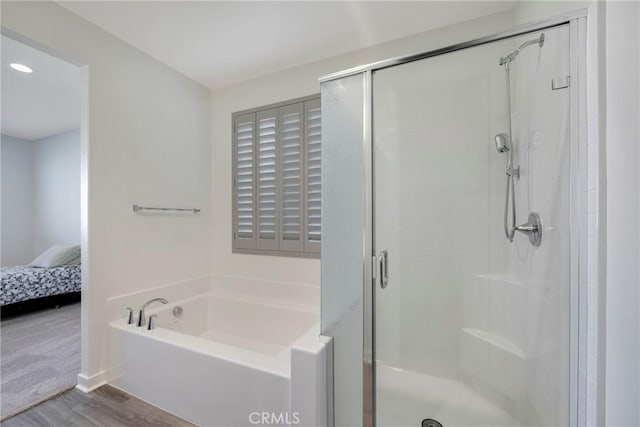 bathroom with wood-type flooring and independent shower and bath