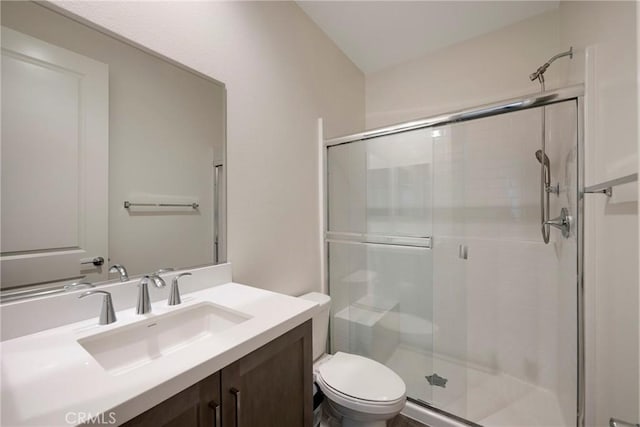 bathroom featuring vanity, an enclosed shower, and toilet